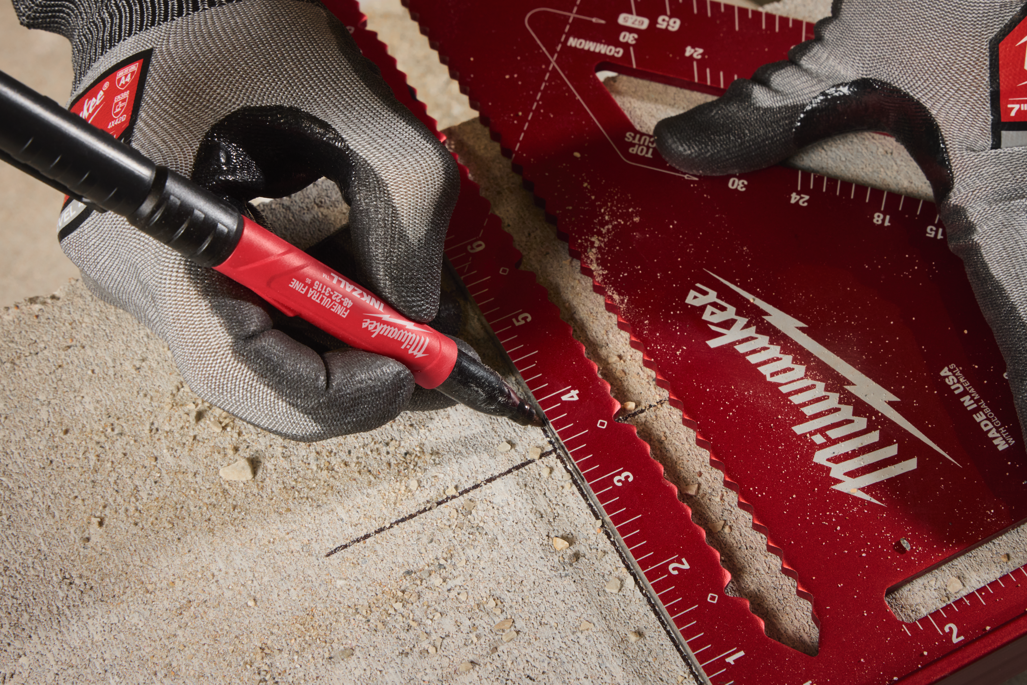 Person using a Milwaukee tool on concrete with a red marker