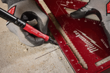 Person using a Milwaukee tool on concrete with a red marker