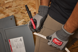 Person wearing Milwaukee gloves using a tool on a wooden surface