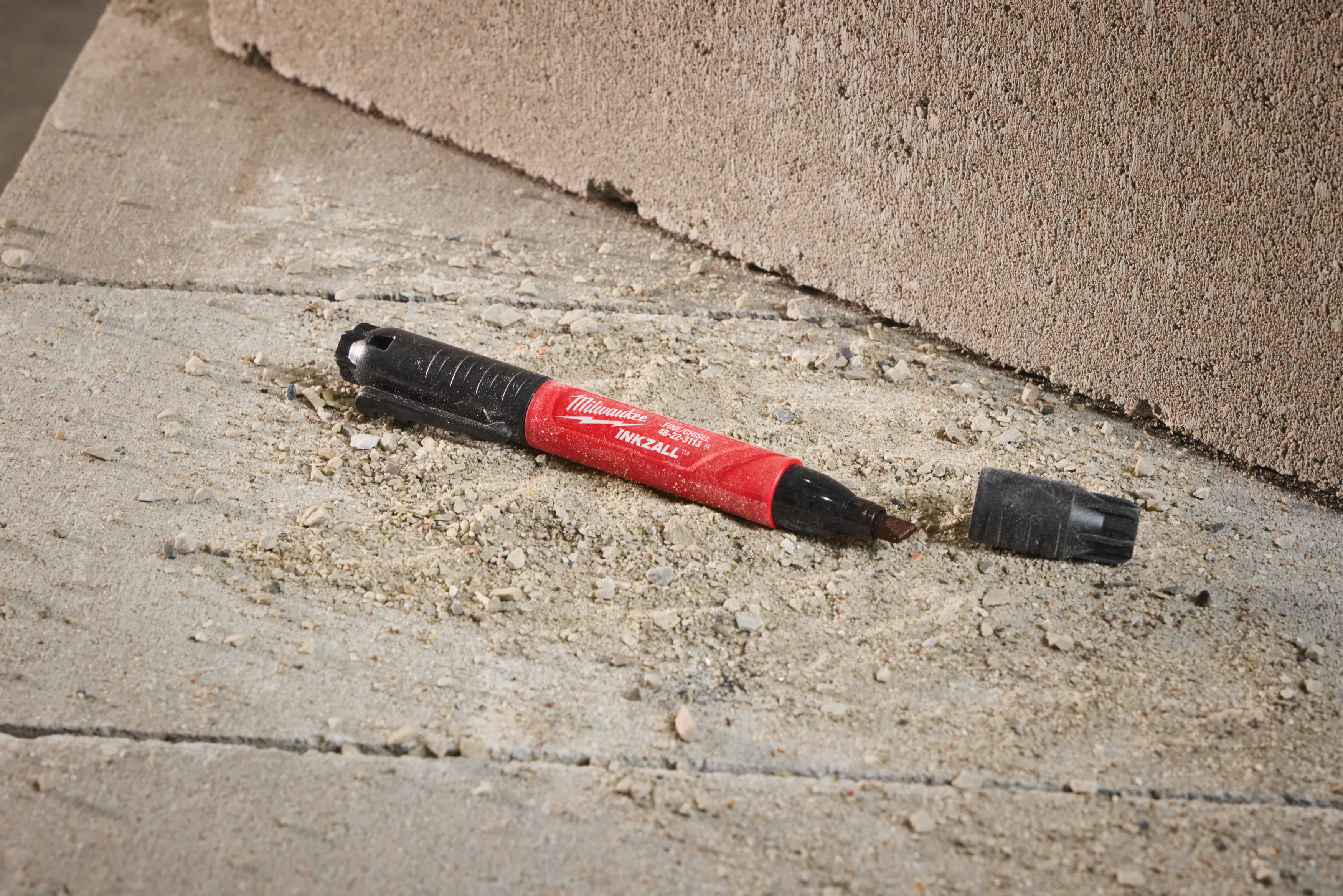 Red and black Milwaukee tool on a concrete surface
