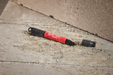Red and black Milwaukee tool on a concrete surface