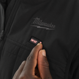 Black jacket with Milwaukee logo and M12 label, hand touching the jacket.