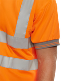 Close-up of a high visibility  orange safety polo shirt sleeve with reflective stripes on a white background